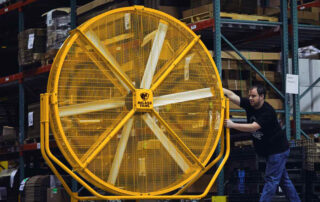 BAF Big Ass Fans directional barrel fan AirGo man pushing moving in warehouse racking