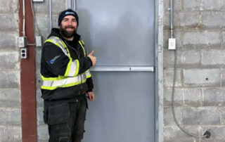 After new man passage entrance swing door ottawa warehouse with installation technician